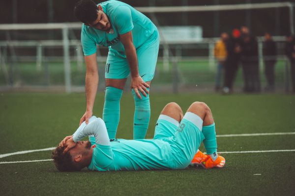 How can football clubs support players in managing the pressures of professional sports?